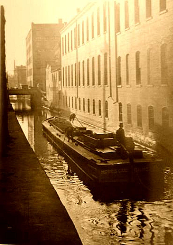 Looking west from Broad Street
This is a photo of the Morris Canal looking west from about 100 feet west of Broad Street.  The building on the right is L. S. Plaut Department Store.  The first bridge is Halsey Street and you can see the inclined plane in the distance that went from Plane Street to Summit Street.
Photo from Henry A. Jewell
