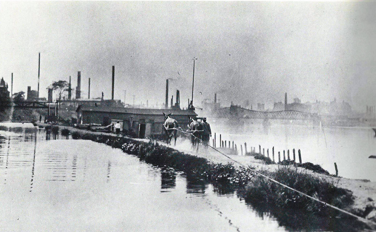 Oxford Street Area
This is a photo (year unknown) of the Morris Canal and the Passaic River.  Most likely taken at the end of Oxford Street.  The Jackson Street Bridge is in the background.  The pedestrian walkway on the left side over the canal was slightly west of Mott Street.  The building in the center was Christman & Koops - Flagpoles, Spars & Derricks.  Note the two mules that are pulling a barge (out of sight).
